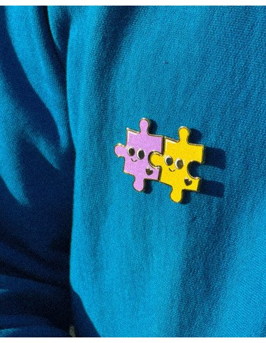 Pin's Puzzle - Grenier Ludique - violet et jaune sur un pull