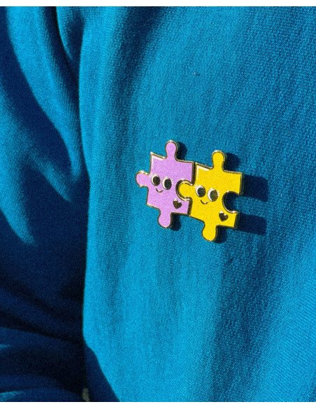 Pin's Puzzle - Grenier Ludique - violet et jaune sur un pull