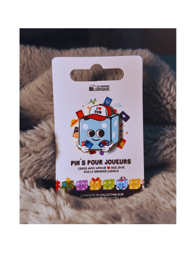 Pin's I love TCG - Grenier Ludique posé sur un tissus Pin's I love TCG - Grenier Ludique posé sur un tissus