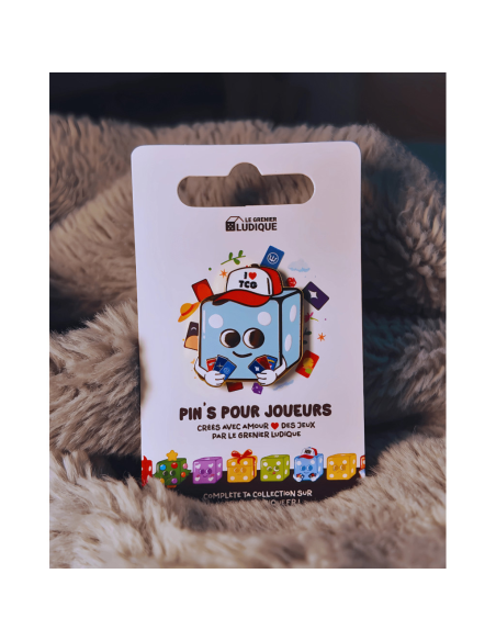 Pin's I love TCG - Grenier Ludique posé sur un tissus Pin's I love TCG - Grenier Ludique posé sur un tissus
